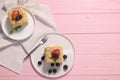 Pieces of delicious Napoleon cake with fresh berries served on pink wooden table, flat lay. Space for text Royalty Free Stock Photo