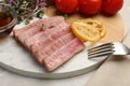 Pieces of delicious tuna steak with microgreens and lemon on table, closeup