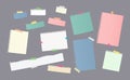 Pieces of different size colorful note, notebook, copybook paper sheets stuck with sticky tape on gray background