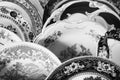 Pieces displayed in a group of multiple textured plates and blue crystal glasses cups [Black and White version]