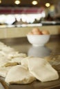 Pieces of dough to be made into roti canai, bowl of eggs in the background