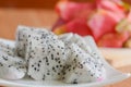 Pieces of dragon fruit on white dish on wooden table,Tropical fruit from Thailand