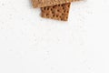 Slices of dry diet crisp bread and crumbs isolated on white background. Close up, top view, space for text. Royalty Free Stock Photo