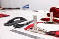 Pieces of fabric, measurements, scissors and other tools on white table in professional workshop, closeup Royalty Free Stock Photo