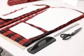Pieces of fabric, measurements, scissors and other tools on white table in professional workshop, closeup Royalty Free Stock Photo