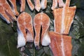 Pieces and fillet of salmon to portions on ice in supermarket. Sale of seafood, fish. Royalty Free Stock Photo