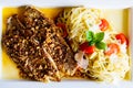 Pieces of fresh crispy breaded fish with noodle and vegetable served on plate. Top view, close up Royalty Free Stock Photo