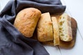 Pieces of fresh crispy ciabatta bread in a grey cloth at wooden desk Royalty Free Stock Photo