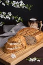 Pieces of fresh homemade rye bread with clay mug of milk on wooden cutting board. Healthy breakfast Royalty Free Stock Photo