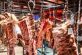 Pieces of fresh raw lamb hanging on hooks in refrigerator