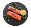 Pieces of fresh raw salmon, spices and lemon on white background, top view