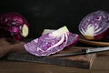 Pieces of fresh red cabbage and knife on wooden table Royalty Free Stock Photo