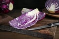 Pieces of fresh red cabbage and knife on wooden table, closeup Royalty Free Stock Photo