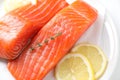 Pieces of fresh salmon with thyme and lemon on white table, above view Royalty Free Stock Photo