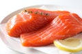 Pieces of fresh salmon with thyme and lemon on white table, closeup Royalty Free Stock Photo