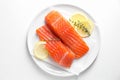 Pieces of fresh salmon with thyme and lemon on white table, top view Royalty Free Stock Photo