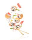 Pieces of fresh sushi with chopsticks frozen in the air on white Royalty Free Stock Photo