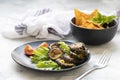 Pieces of fried bitter gourd served with lettuce leaves on a marble table. exotic spicy snack karela. Indian cuisine. Copy space Royalty Free Stock Photo