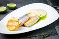 pieces of fried fish with sauce and fried lemon on a white plate side view Royalty Free Stock Photo