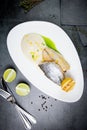 pieces of fried fish with sauce and fried lemon on a white plate top view Royalty Free Stock Photo