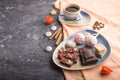A pieces of homemade chocolate with coconut candies and a cup of coffee on a black concrete background. side view, copy space Royalty Free Stock Photo