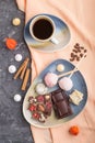 A pieces of homemade chocolate with coconut candies and a cup of coffee on a black concrete background. top view, close up Royalty Free Stock Photo