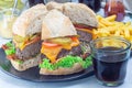 Pieces of huge giant homemade cheeseburger for burger party on plate, horizontal Royalty Free Stock Photo