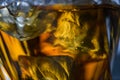 Pieces of ice cube in whiskey. Close up macro of Ice cubes in glass drink or another alcohol Royalty Free Stock Photo