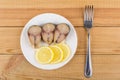 Pieces of mackerel, slices of lemon in plate, fork Royalty Free Stock Photo