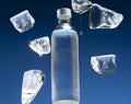 Pieces of melting ice around a water bottle. Water condensate on the surface of the bottle Royalty Free Stock Photo