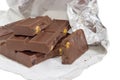 Pieces of the milk chocolate in open foil wrapper closeup Royalty Free Stock Photo