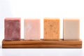 Pieces of natural soap of different scents on a wooden board on a white background.Handmade soap