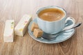 Pieces of nougat with marmalade, coffee in cup, sugar, spoon on saucer on table Royalty Free Stock Photo