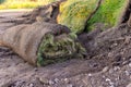 Pieces of old used roll lawn lie in a heap