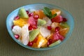 A small blue bowl with multicolored fruits.