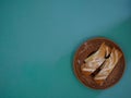 Antique handmade earthenware plate decorated with birch bark with slices of delicious bird cherry pie on a green