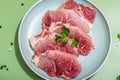 Pieces of pork meat with parsley on gray dish, raw fresh steaks concept. Sea salt, spices Royalty Free Stock Photo