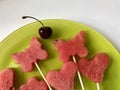 Pieces of the pulp of watermelon are cut with a stamp. They are given different forms. Stringed on skewers for a picnic. There are