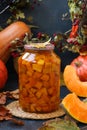 Pieces pumpkin canned for the winter in a jar located on a dark background