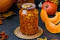 Pieces pumpkin in jar located on a dark background, harvesting vegetables for the winter, horizontal orientation
