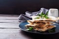 Pieces of quesadilla with mushrooms sour cream and cheese on a plate with parsley leaves. Wooden background copy space