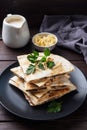 Pieces of quesadilla with mushrooms sour cream and cheese on a plate with parsley leaves. Wooden background copy space.