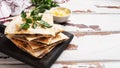 Pieces of quesadilla with mushrooms sour cream and cheese on a wooden stand with parsley leaves. Wooden background copy space