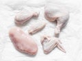 Pieces of raw butchered chicken - legs, thighs, breast, wing on a light background, top view. Raw food ingredients for cooking Royalty Free Stock Photo