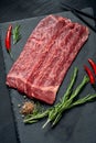 Pieces of raw marble beef black Angus for grilling on a stone Board on a dark background. Meat for yakiniku Royalty Free Stock Photo