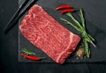 Pieces of raw marble beef black Angus for grilling on a stone Board on a dark background. Meat for yakiniku Royalty Free Stock Photo