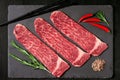 Pieces of raw marble beef black Angus for grilling on a stone Board Royalty Free Stock Photo