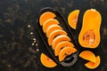 Pieces of raw pumpkin on a black ceramic dish. Top view, copy space. The concept of autumn. Halloween Royalty Free Stock Photo