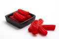 Pieces of red licorice on black bowl