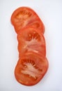 Pieces of red tomato on a white background. Chopped tomatoes